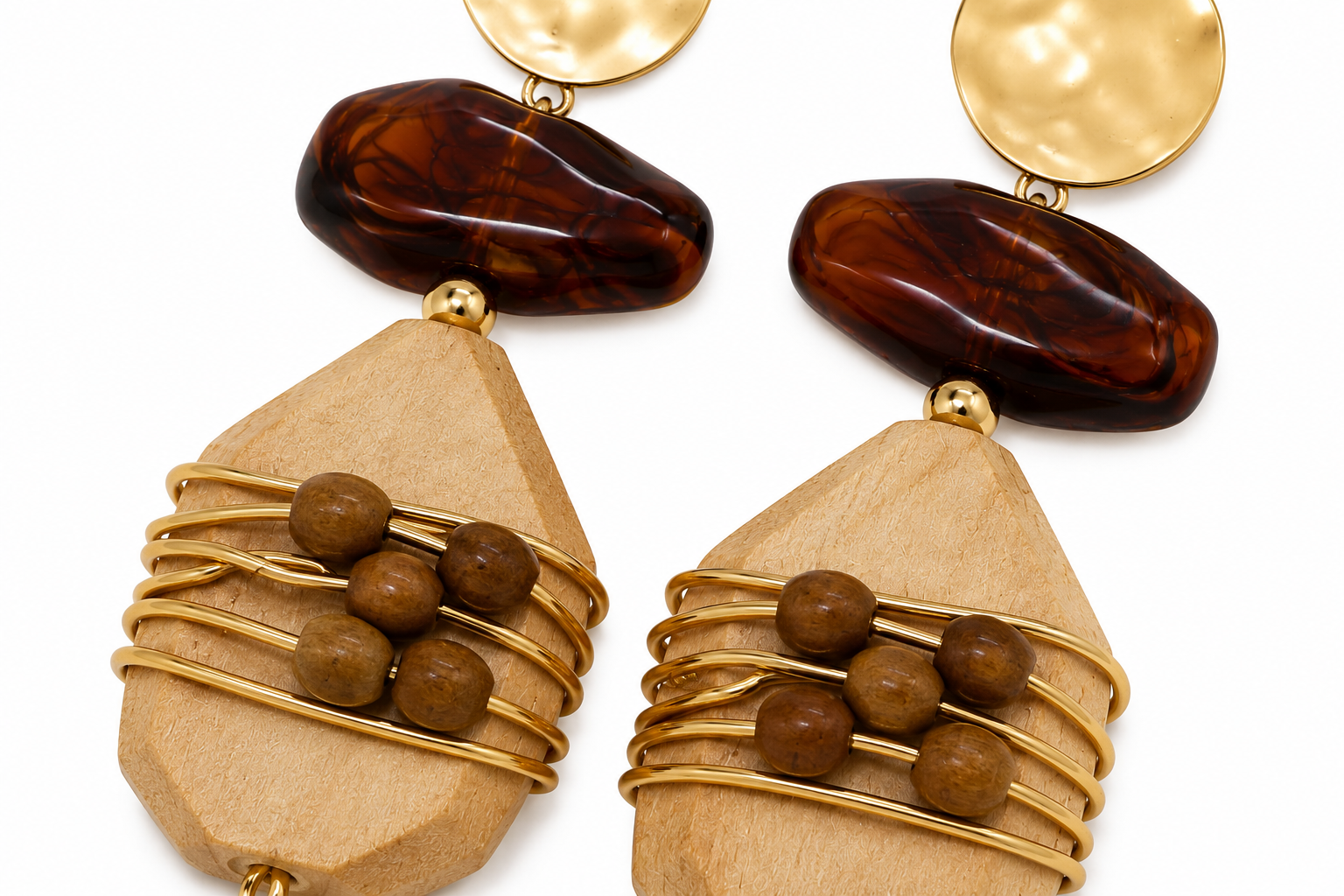A pair of bohemian dangle earrings featuring natural wood geometric pendants, wrapped in gold wire with small brown wooden beads, topped with dark brown polished stone drops and hammered gold disc charms, shown on a white background.
