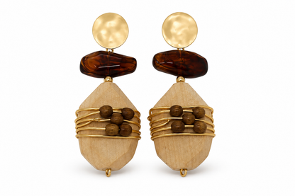 A pair of bohemian-style drop earrings featuring light wood geometric pendants wrapped in gold wire, dark brown wooden beads, a dark brown stone, and a hammered gold disc stud, shown on a white background.