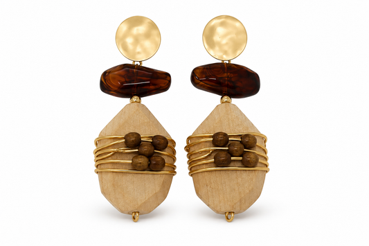 A pair of bohemian-style drop earrings featuring light wood geometric pendants wrapped in gold wire, dark brown wooden beads, a dark brown stone, and a hammered gold disc stud, shown on a white background.